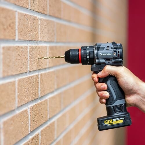 Person using a cordless drill on a brick wall