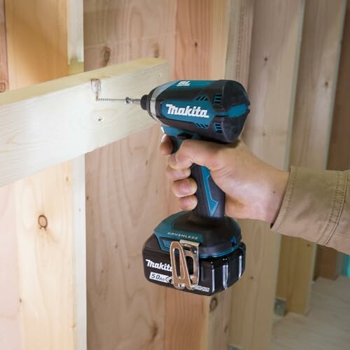Person using a cordless drill on wooden boards.