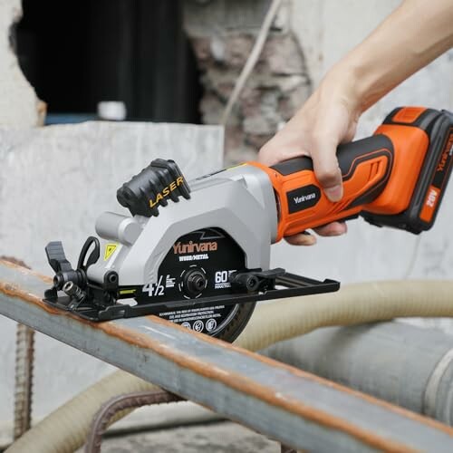 Hand holding a handheld circular saw cutting metal.